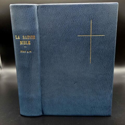 Vue du dos et du plat d'une reliure plein cuir bleue, décorée en dorure à la main d'une croix.